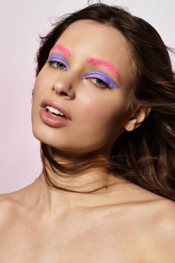 Canlı makyajlı genç bir kadın, yaratıcılığını gri bir arka planda sergiliyor..