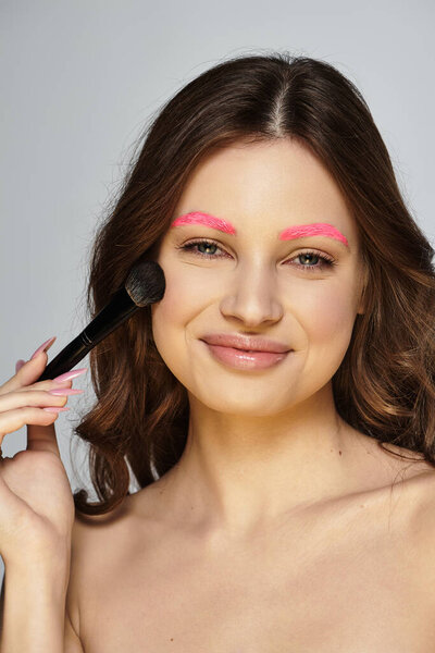 Молодая женщина подчеркивает свои яркие розовые брови, демонстрируя уникальный стиль красоты.