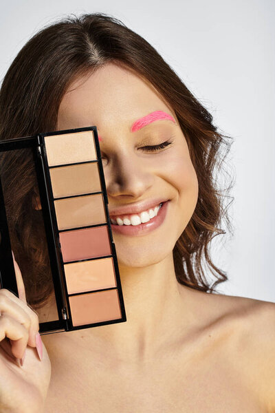 Привлекательная молодая женщина демонстрирует свой уникальный стиль и игривую уверенность в студии.