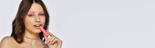 Молодая женщина демонстрирует свой яркий макияж с яркими фиолетовыми тенями для век и розовыми бровями, баннером