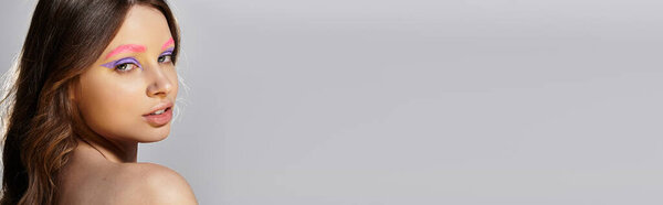 Молодая женщина демонстрирует смелый макияж с фиолетовыми тенями для век и розовыми бровями, баннер