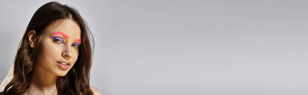Уверенная молодая женщина с смелым макияжем: яркие фиолетовые тени для век и розовые брови, баннер
