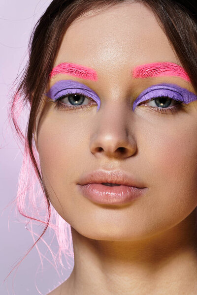 Молодая женщина с смелым макияжем и творческими цветами подчеркивает современные тенденции красоты.