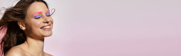 Молодая женщина демонстрирует свою завораживающую красоту с яркими розовыми бровями и пурпурными тенями для век, баннером