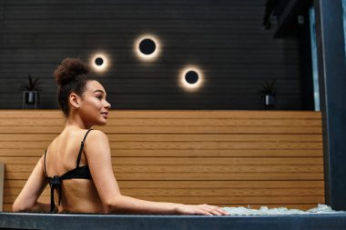 Genç ve şık bir kadın sakin bir kaplıcada dinleniyor, rahatlatıcı bir atmosfere dalıyor..