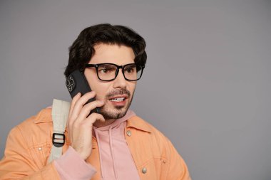 Kahverengi saçlı şık bir genç adam hareketli sohbetler yapıyor..