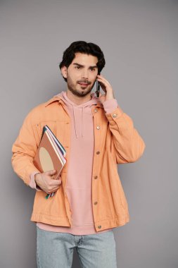 Esmer adam, çağdaş uzayda renkli defterler taşıyan bir telefon görüşmesinde bulundu..
