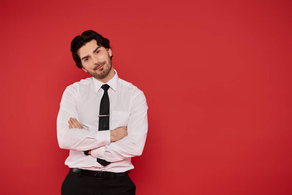 Красивый брюнетка мужчина представляет расслабленной, но уверенной в себе осанке в элегантном наряде.