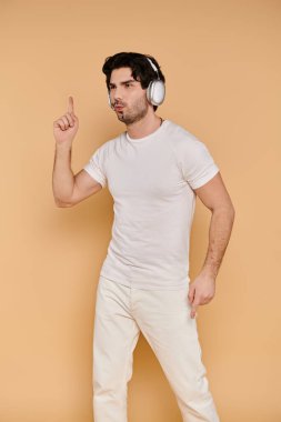 Canlı, esmer bir adam kulaklık takmış, enerji saçan ve müzik eşliğinde neşeyle dans ediyor..