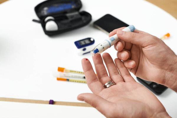 A young man demonstrates his daily routine managing diabetes in a modern apartment setting.