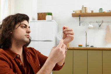Kafkas diyabeti olan bir adam modern bir apartman ortamında kan şekerini ölçüyor..