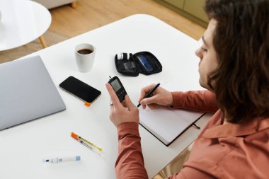 Beyaz adam modern apartman ortamında kan şekeri seviyelerini ve belgelerini izliyor..
