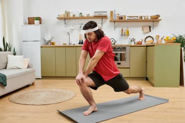 A good looking young man practices his home workout routine in a stylish apartment. clipart