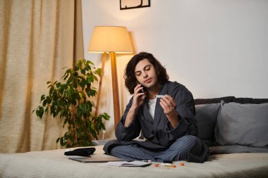 Genç bir adam telefonda sağlık durumunu tartışırken insülinini kontrol ediyor..