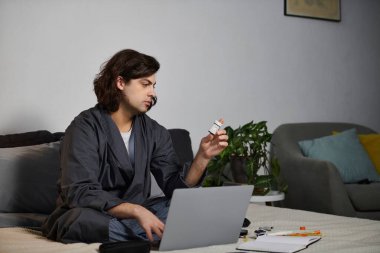Genç bir adam rahat bir apartman dairesinde yaşam tarzını dengelerken insülinini kontrol eder..