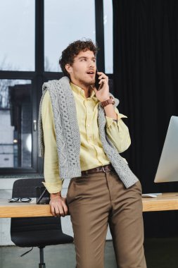 Kıvırcık saçlı bir genç, şık bir ofiste gündelik hayatıyla ilgili konuları tartışır..