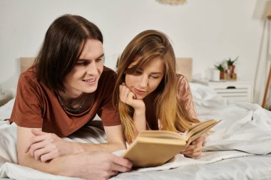 İki genç, yatakta büyüleyici bir kitap okurken birbirlerine eşlik etmekten zevk alırlar..
