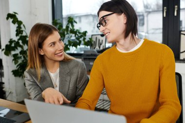 İki şık genç, ofiste iş tartışırken keyifli bir anı paylaşıyor..
