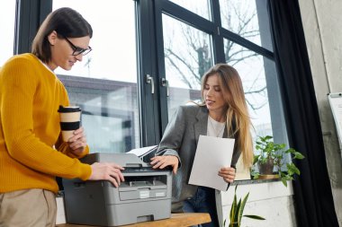 İki genç profesyonel, şık bir ofis alanında ortak bir işe giriştiler, fikirleri paylaştılar..