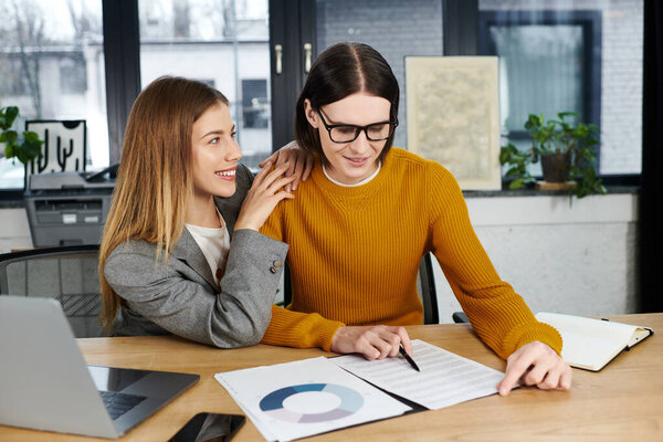 Two young individuals engage in creative collaboration at a stylish workspace while sharing ideas.