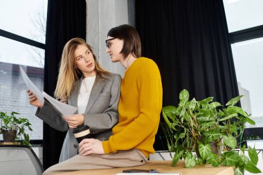 Nişanlı genç çift, yeşilliklerle çevrili şık bir çalışma alanında yaratıcı fikirler üzerinde işbirliği yapıyor..