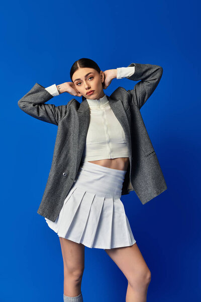 Красивая молодая женщина демонстрирует свое чувство стиля с поразительной позой и вдумчивым взглядом.