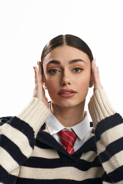 A young woman with a striking expression is holding her head, showcasing her emotions and style.