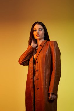 Genç bir kadın şık giyinmiş ve göz kamaştırıcı bir makyaj yapıyor..