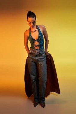 Genç bir kadın bir stüdyoda şık bir yılan desenli kıyafet ve göz kamaştırıcı bir makyaj modeli..