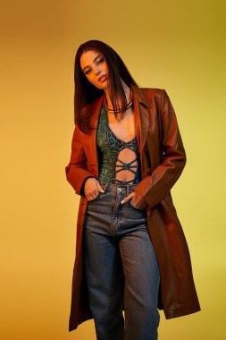 Kendine güvenen genç kadın, canlı bir stüdyo ortamında moda yılan baskısı modasını sergiliyor..