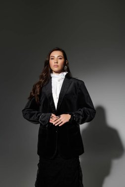 Uzun kahverengi saçlı güzel bir kadın şık giyiniyor şık bir stüdyoda..