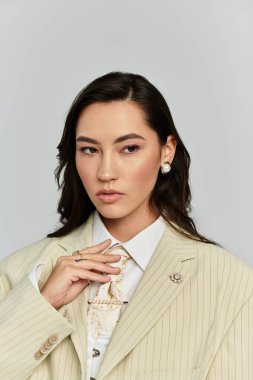 Şık bir kadın modern bir arkaplanda zarafetle poz verirken moda anlayışını sergiliyor..