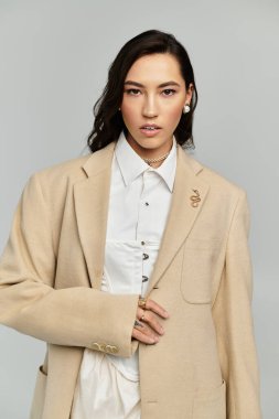 Young woman shows off her style in a chic beige blazer and matching accessories. clipart