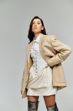 Kendine güvenen genç bir kadın moda anlayışını kapalı mekan ortamında sergiliyor..