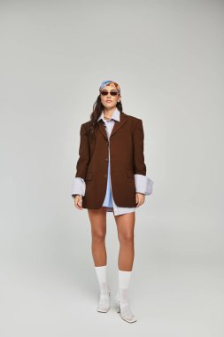 Güzel bir kadın modayla dimdik ayakta duruyor, modern bir yerde cesur moda seçimleri sergiliyor..