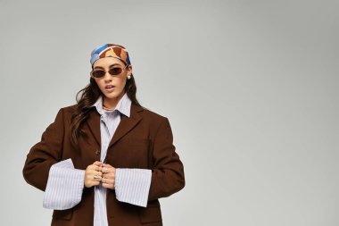 Kendine güveni tam genç bir kadın şık bir elbise içinde poz veriyor. Yumuşak bir zemin, ışıl ışıl bir tarz ve zarafet..