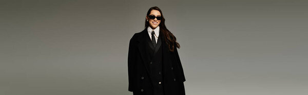 Красивая молодая женщина с длинными каштановыми волосами демонстрирует свой стильный ансамбль в студии, баннер