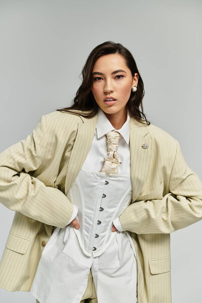 Stylish young woman poses confidently, blending modern fashion with timeless elegance in soft light.