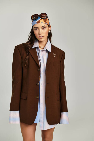 Молодая женщина демонстрирует красочный, текстурированный наряд на светлом фоне.