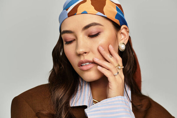 Изящная женщина в шикарном платке и стильных украшениях источает уверенность.