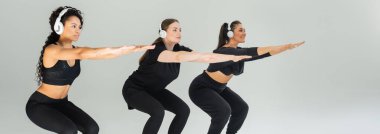 Üç güçlü kadın modern bir spor salonunda birlikte çömeliyor, birlik ve zindelik gösteriyorlar..