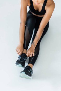 Sporcu spor ayakkabılarını bağlamaya odaklanıyor. Enerjik bir spor programı yapmaya hazır..