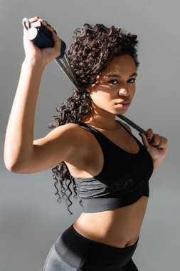 Formda ve güzel bir kadın şık bir spor salonunda ağırlığını kaldırıp gücünü sergiliyor..