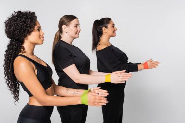 Üç sağlıklı kadın senkronize fitness egzersizi yapıyor, dayanıklılık ve takım çalışması..
