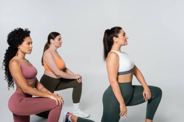 Formda üç kadın spor yaparken güç ve kararlılık gösteriyor..
