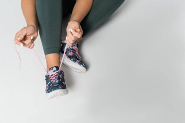 Güçlü bir dişi ayakkabılarını hazırlıyor, zorlu bir fitness rutininden önce görevine odaklanıyor..