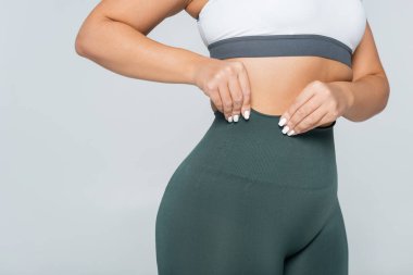 Güçlü bayan sporcu spor kıyafetlerini spor salonunda özgüvenle ayarlıyor.
