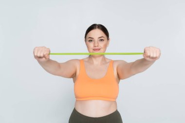 Kadın fitness meraklısı içeride dayanıklılık eğitimi için direnç bandı egzersizleri yapıyor.