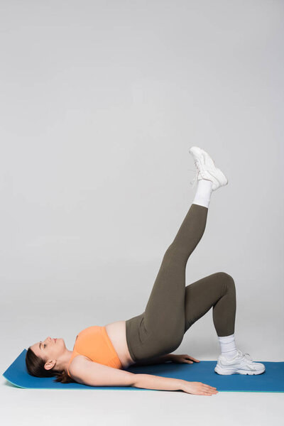 A determined woman is engaged in a fitness routine, showcasing strength and focus while exercising.