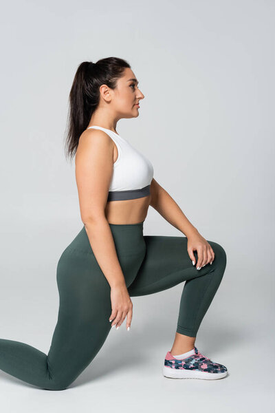 Подтянутая спортсменка уверенно выпрыгивает в стильном спортивном снаряжении, демонстрируя свою силу.